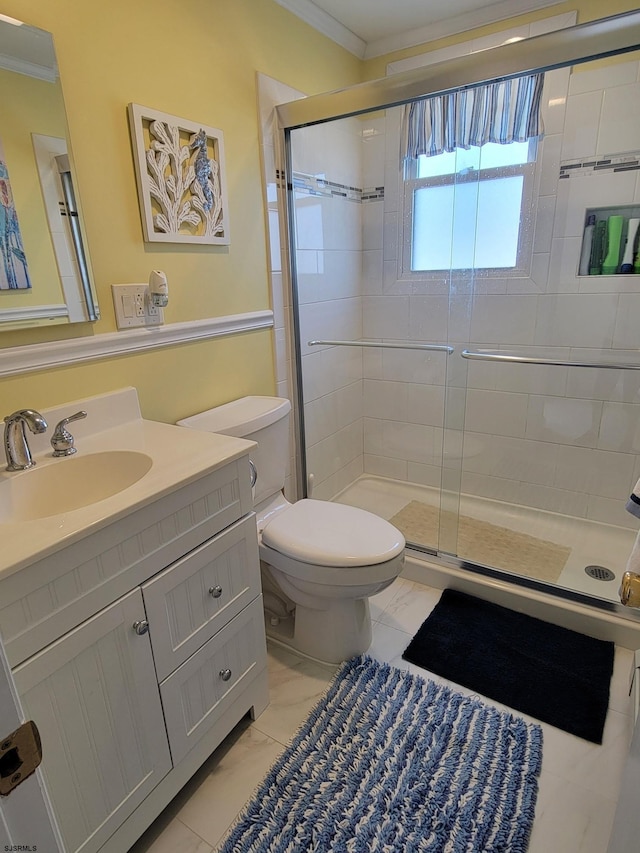 bathroom with a stall shower, toilet, ornamental molding, marble finish floor, and vanity