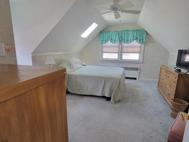 bedroom featuring radiator, ceiling fan, vaulted ceiling, and light colored carpet