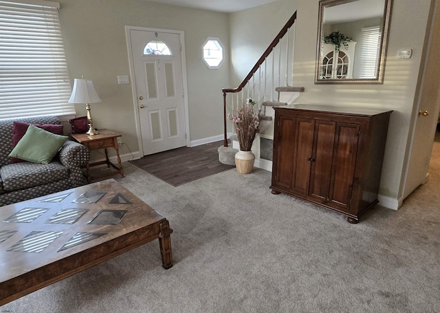 foyer with light colored carpet, baseboards, and stairs