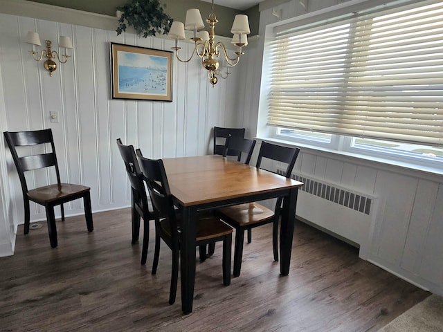 dining area with a chandelier, dark wood-style flooring, and radiator heating unit