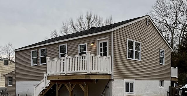 back of property with a deck and stairway