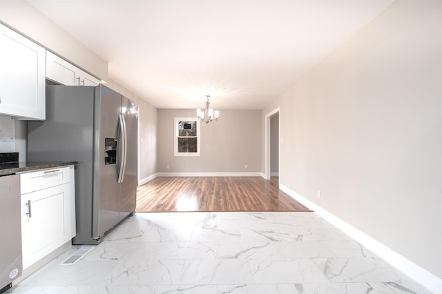 kitchen featuring a notable chandelier, marble finish floor, appliances with stainless steel finishes, and white cabinets