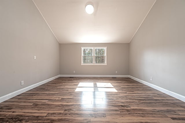 bonus room with lofted ceiling, baseboards, and dark wood-style flooring