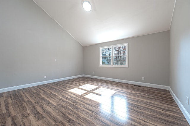 unfurnished room with lofted ceiling, dark wood-style flooring, and baseboards