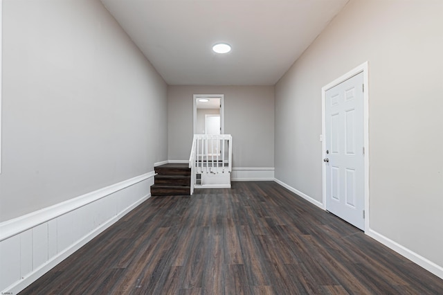 empty room with dark wood-style flooring and baseboards