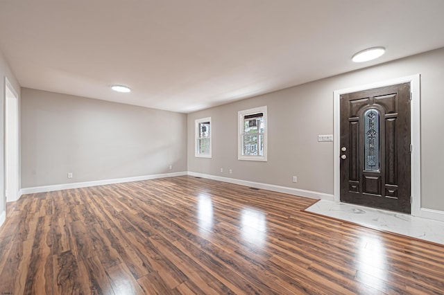 foyer entrance with baseboards and wood finished floors