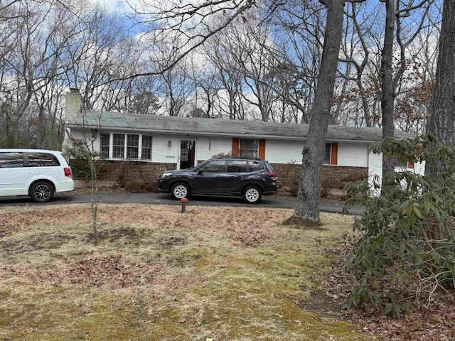 single story home with a chimney and brick siding