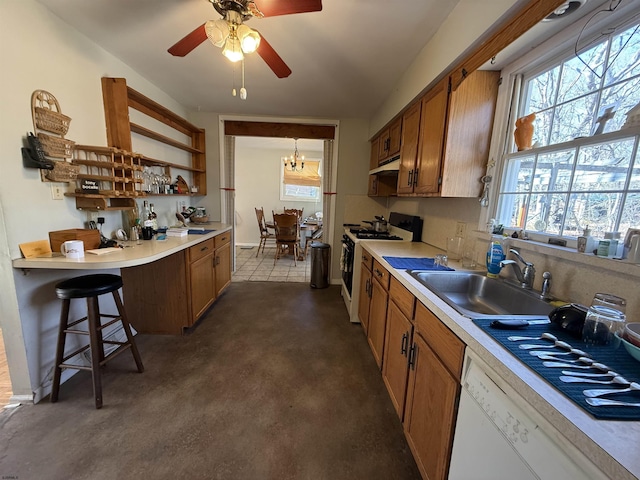 kitchen featuring light countertops, white appliances, a sink, and brown cabinets