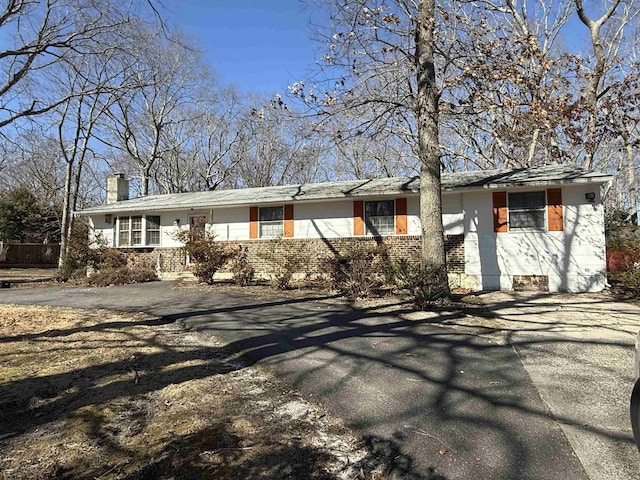 single story home featuring brick siding and a chimney