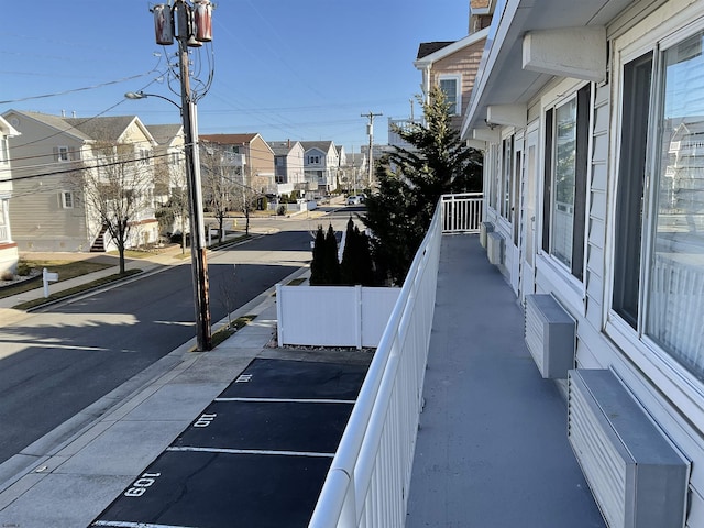 view of street with a residential view, curbs, sidewalks, and street lights