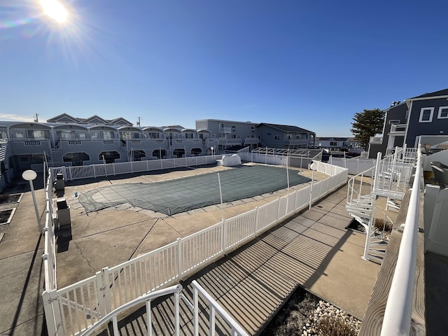 exterior space with a residential view, fence, a community pool, and a patio