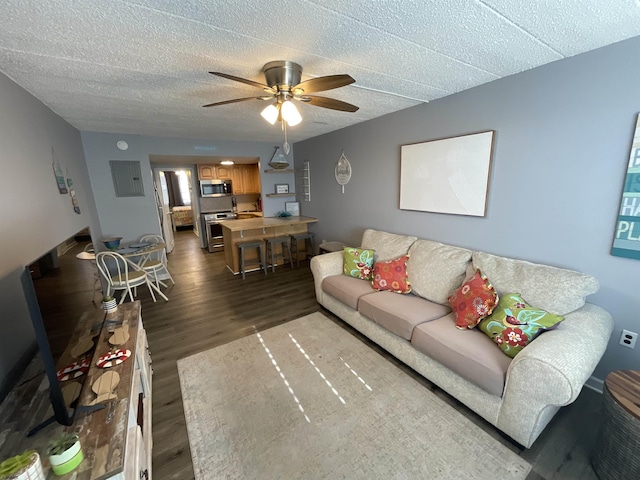 living room with dark wood-style floors, ceiling fan, and a textured ceiling