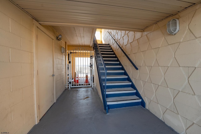 interior space featuring stairway and concrete block wall