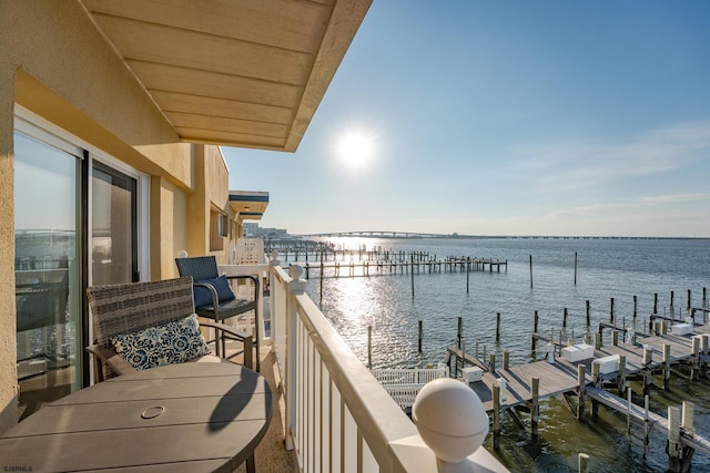 balcony with a water view and a boat dock