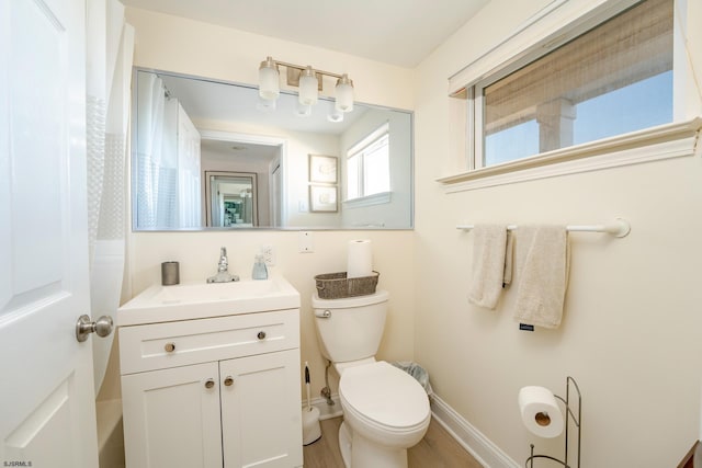 bathroom featuring toilet, baseboards, and vanity