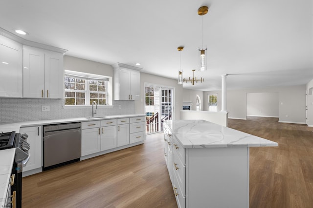 kitchen with a sink, light wood-style floors, open floor plan, appliances with stainless steel finishes, and a center island