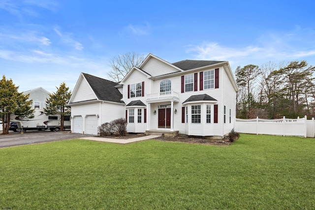 view of front of house featuring a garage, fence, aphalt driveway, and a front yard