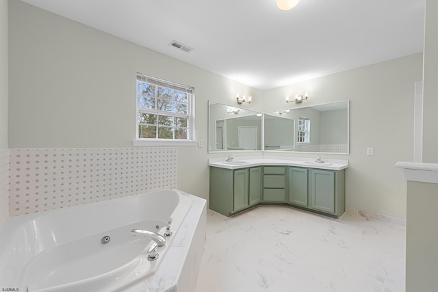 full bath with marble finish floor, visible vents, a sink, and a whirlpool tub