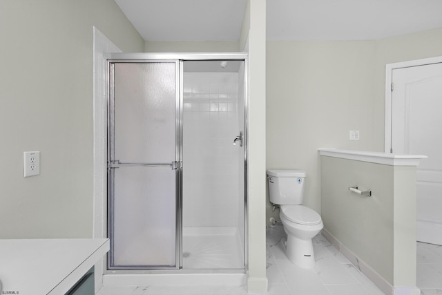 bathroom featuring toilet, marble finish floor, and a shower stall