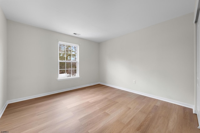 unfurnished room featuring light wood-type flooring, baseboards, and visible vents