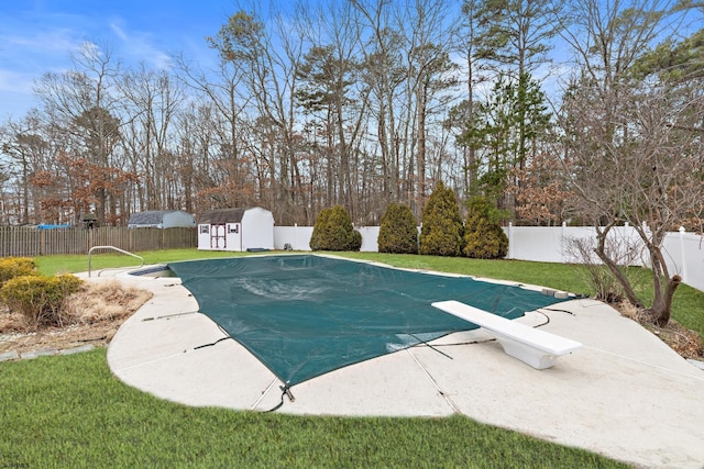 view of pool with a fenced backyard, a yard, and an outdoor structure