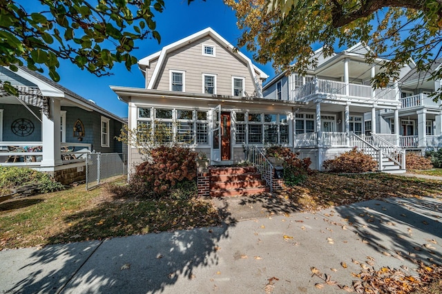 dutch colonial featuring covered porch and a gambrel roof