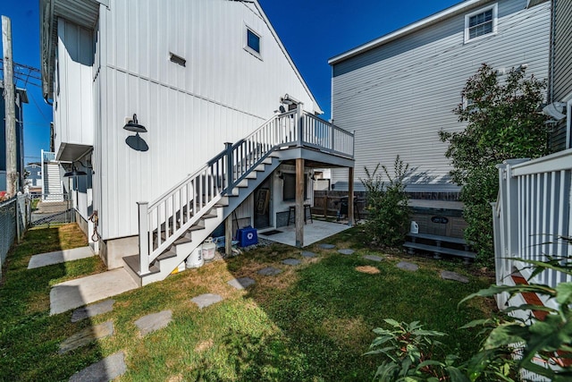 view of property exterior featuring a deck, central AC, fence, stairway, and a patio area