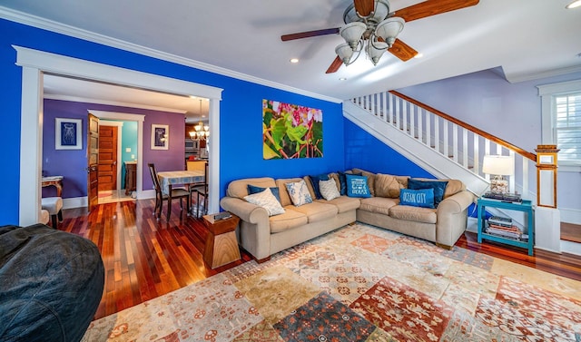 living room with stairs, ceiling fan with notable chandelier, crown molding, and wood finished floors