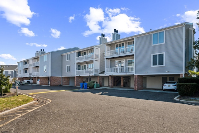 view of building exterior featuring uncovered parking and a residential view