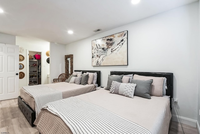 bedroom with visible vents, wood finished floors, a spacious closet, a closet, and recessed lighting