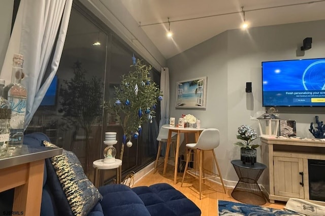 interior space featuring lofted ceiling, wood finished floors, and track lighting