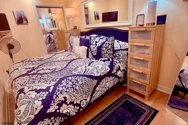 bedroom with baseboards and wood finished floors