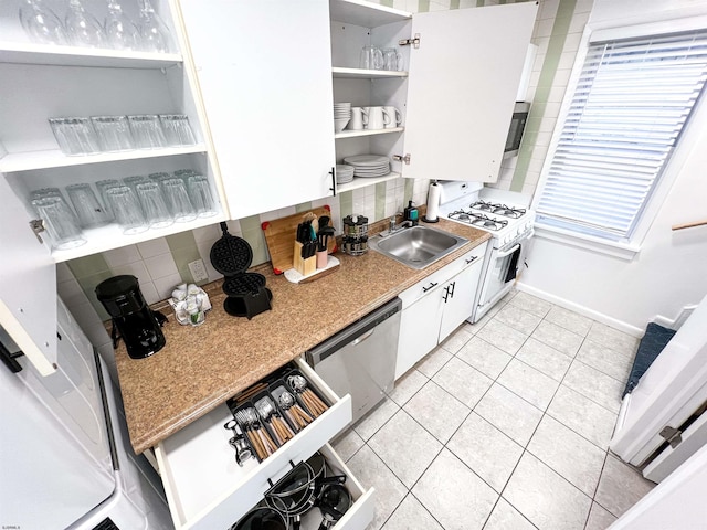 kitchen with open shelves, white gas range, decorative backsplash, stainless steel dishwasher, and a sink