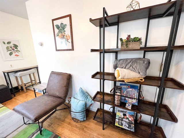 sitting room with baseboards and wood finished floors