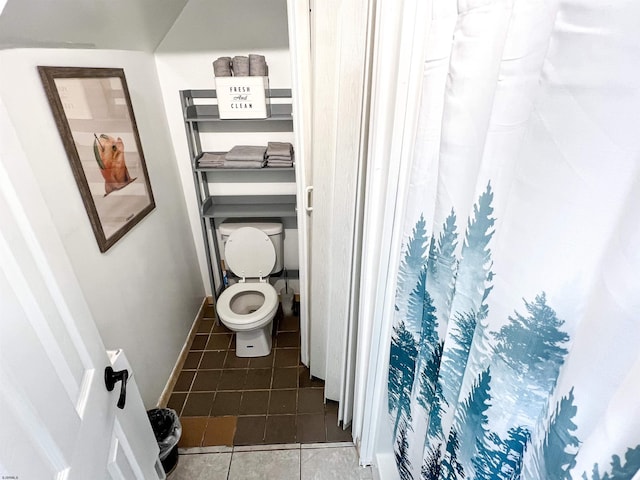 full bath featuring curtained shower, tile patterned flooring, toilet, and baseboards