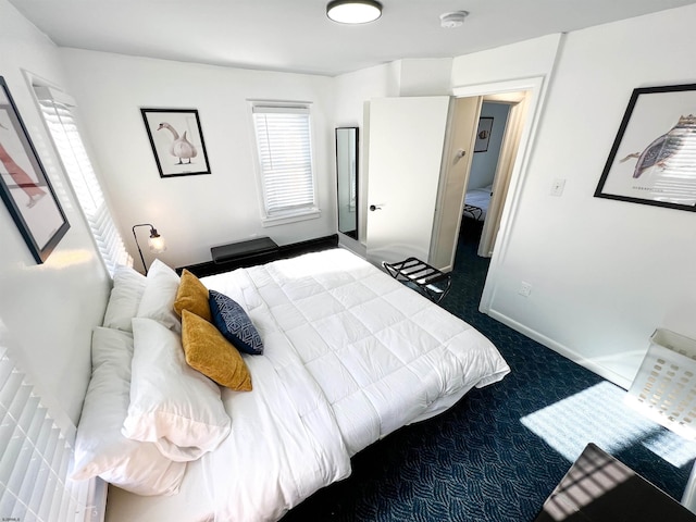 bedroom featuring dark carpet and baseboards