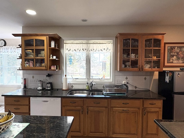 kitchen with a healthy amount of sunlight, white dishwasher, a sink, and freestanding refrigerator