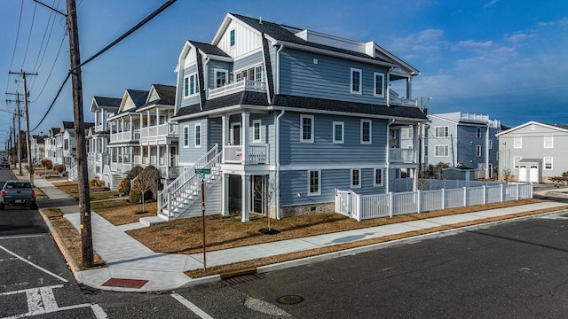 multi unit property with uncovered parking, board and batten siding, fence, and a residential view