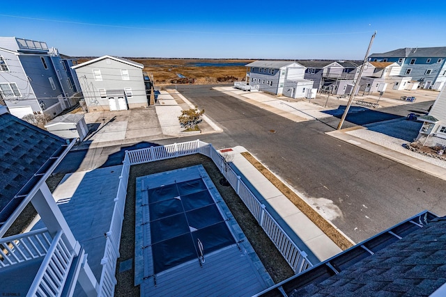 view of swimming pool with a residential view and fence