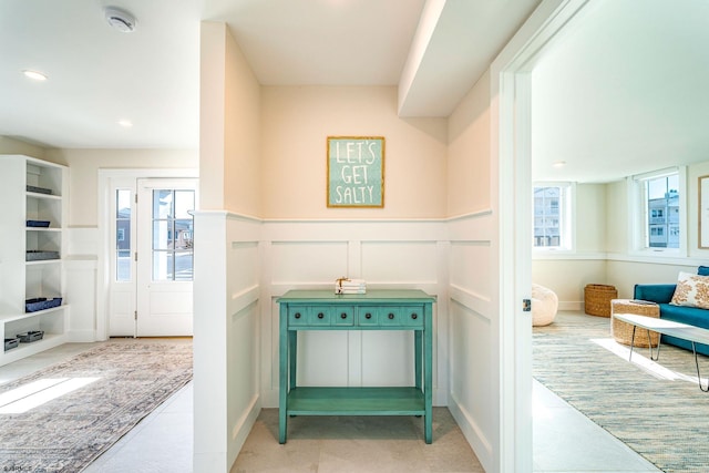 interior space featuring a wainscoted wall, recessed lighting, a wealth of natural light, and a decorative wall