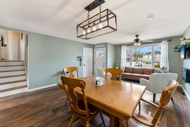 dining space with ceiling fan, dark wood-style flooring, stairs, and baseboards