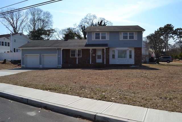 traditional-style house featuring driveway, brick siding, and an attached garage