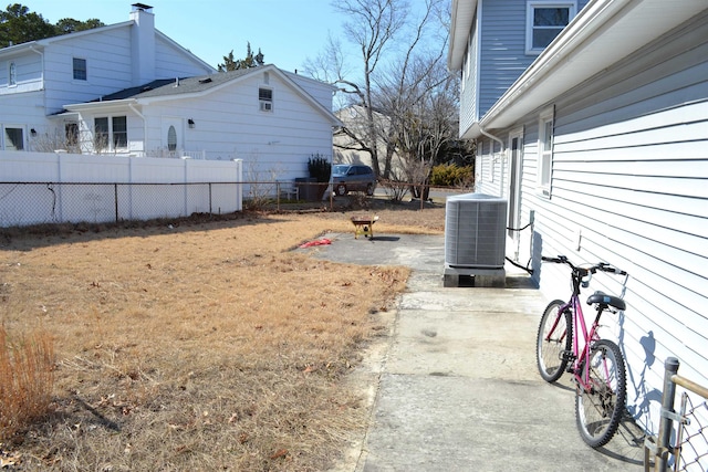 view of yard featuring a patio area, cooling unit, and fence