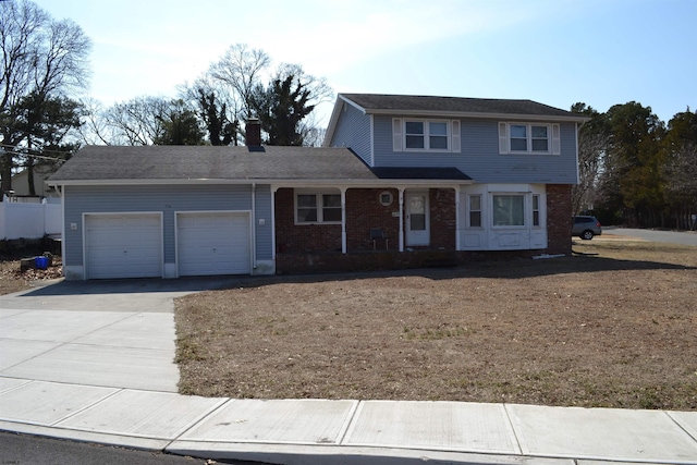 traditional-style home featuring a garage, driveway, brick siding, and a chimney