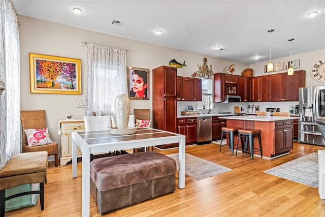 dining area featuring light wood-style flooring and visible vents