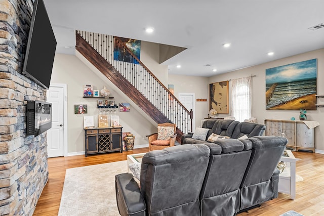 living area with visible vents, baseboards, light wood-style flooring, stairs, and recessed lighting