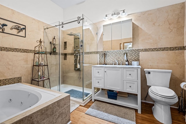 full bath with toilet, a stall shower, tile walls, and wood finished floors