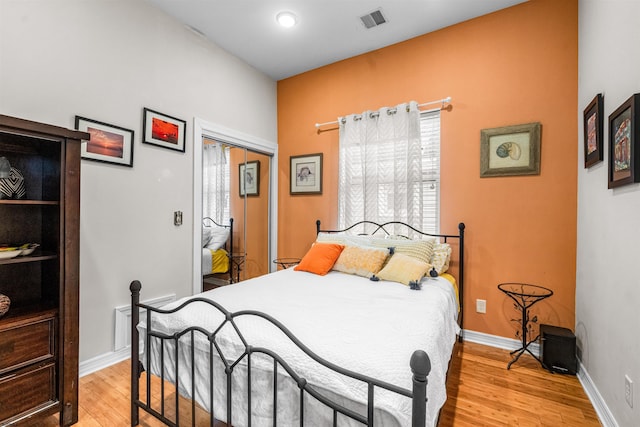 bedroom featuring light wood-style floors, a closet, visible vents, and baseboards