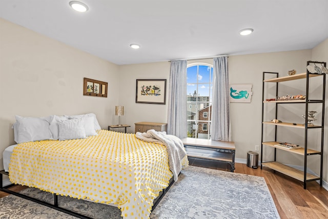 bedroom with baseboards, wood finished floors, and recessed lighting