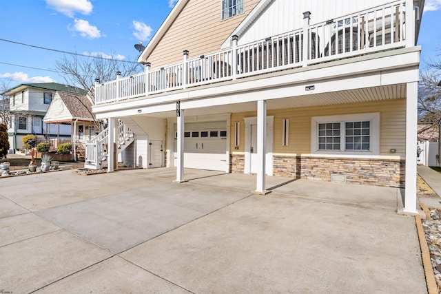 exterior space featuring a garage, stairs, a carport, and concrete driveway